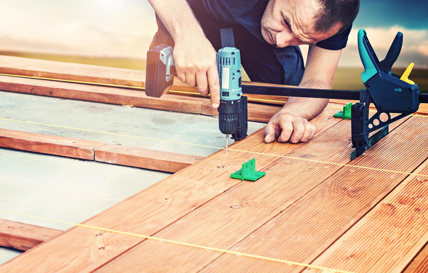 Terrassendielen montieren wie ein Profi mit moderner Unterkonstruktion Mann montiert Terrassendielen aus Holz